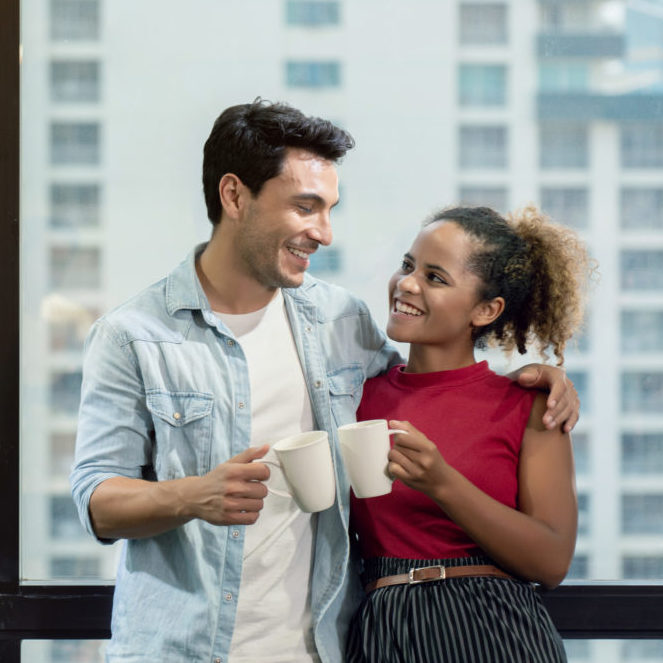 Couples mixed race Standing talking, holding a coffee cup, talki
